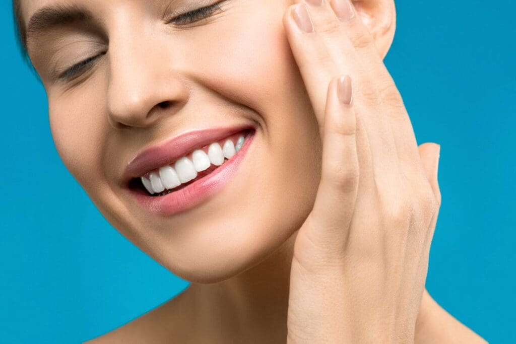 Woman with youthful smile and clear skin against blue background