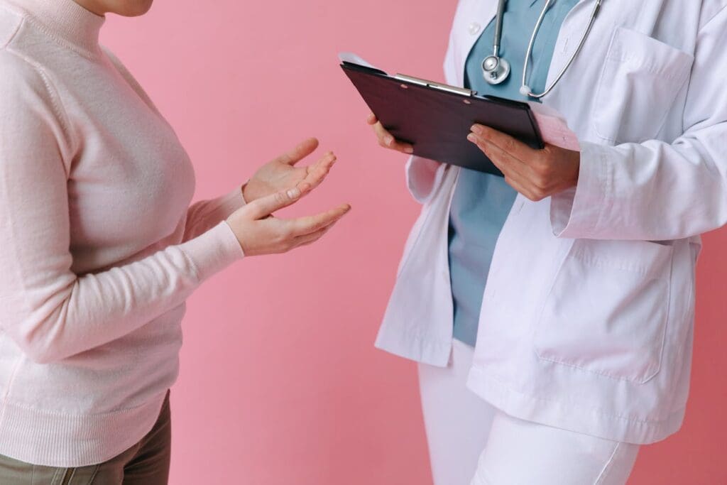 Client consulting a medical professional who’s holding a clipboard