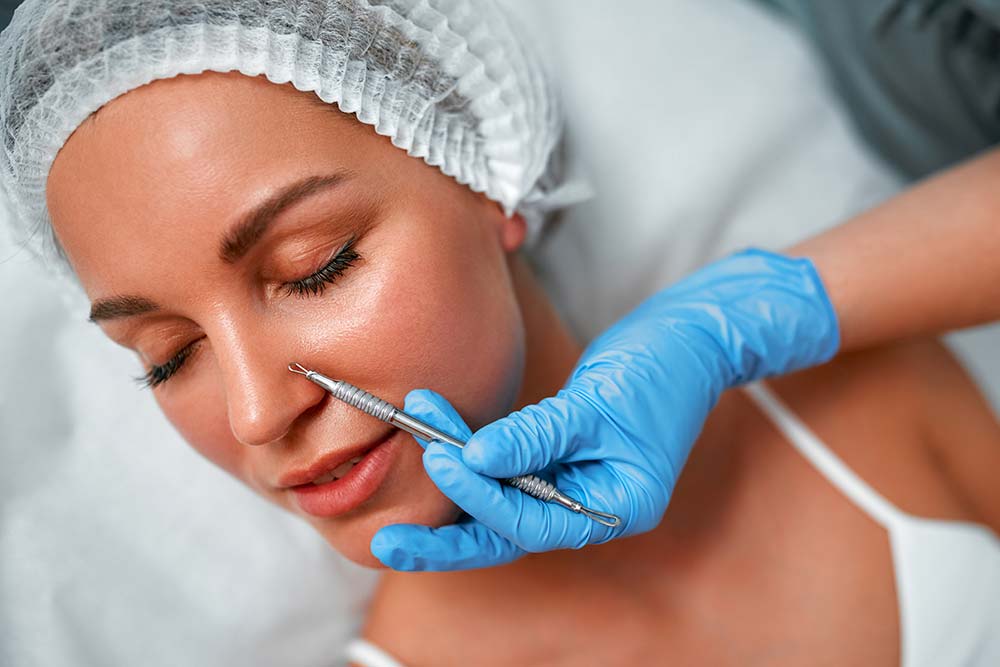 An extraction tool held against a patient’s nose by a gloved hand
