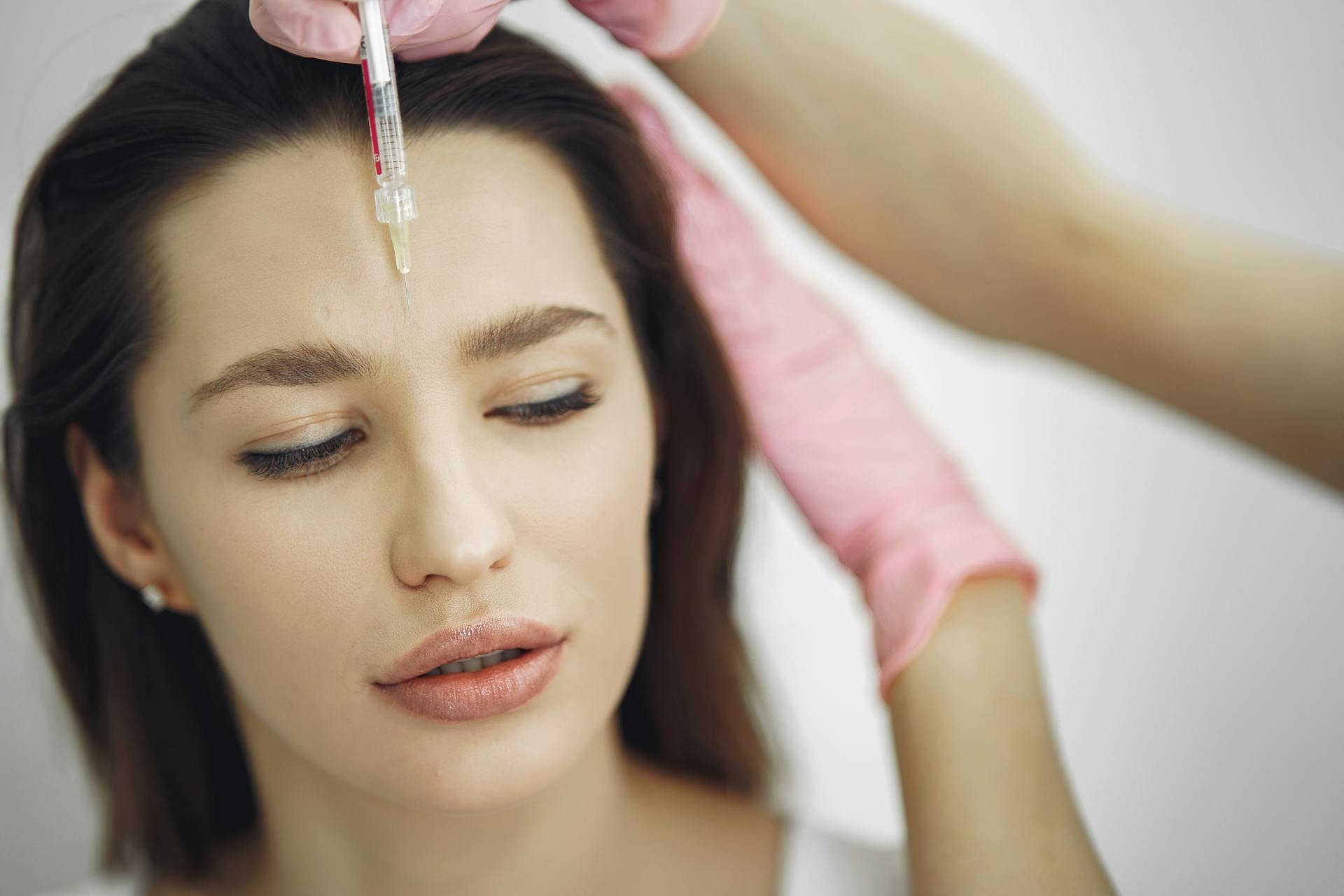 A patient getting injected with Botox for her forehead