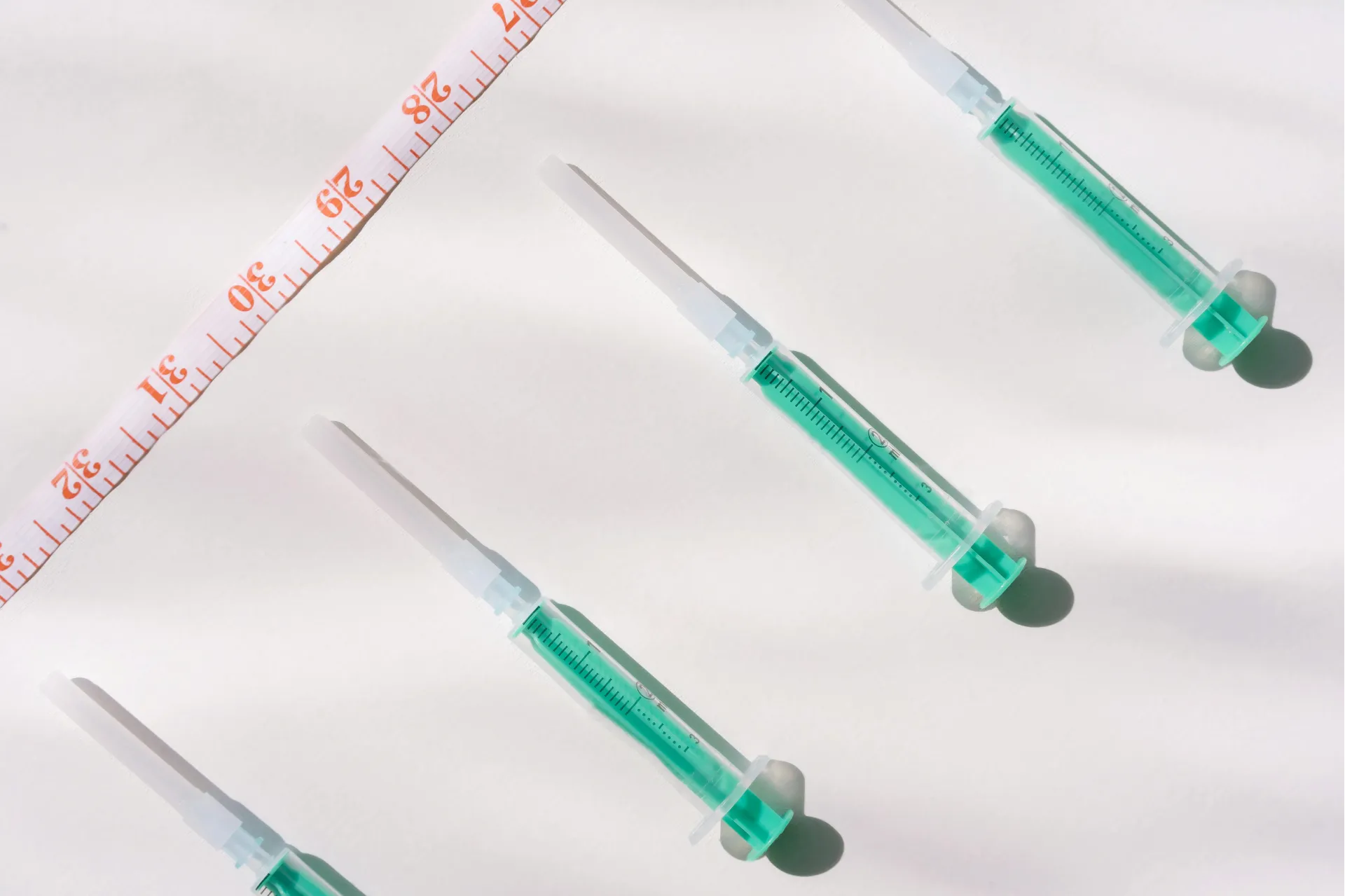 Syringes laid out next to a measuring tape