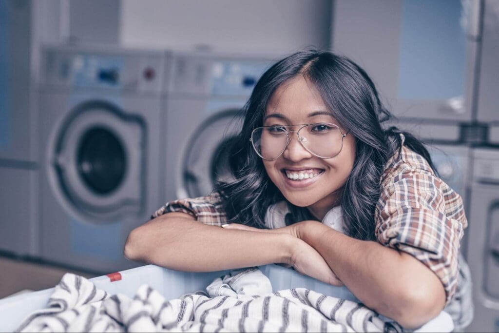 A smiling woman with a basket of laundry