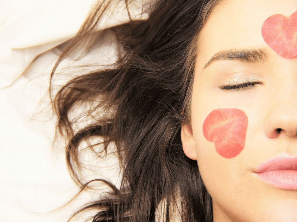 A partial view of a woman’s healthy glowing face with summer strawberry embellishments