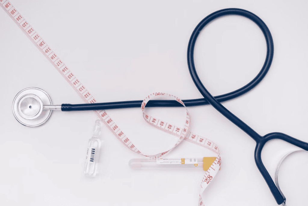 A stethoscope, measuring tape, and vials on a simple background, symbolizing multiple elements of health and wellness optimization